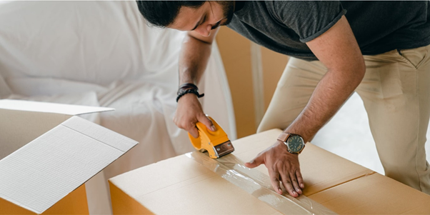 Man taping up a cardboard box with gaffa tape